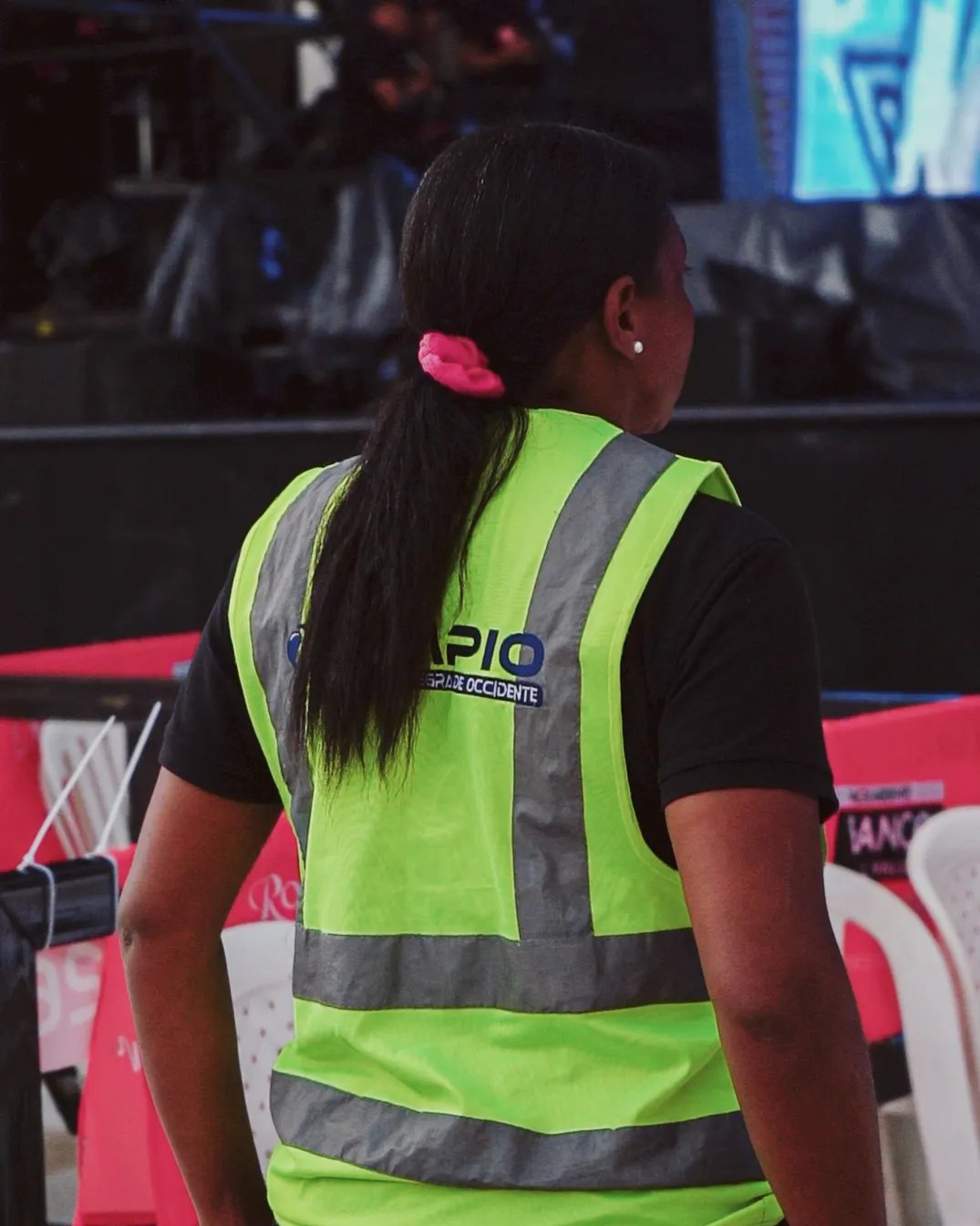 Operaria de Limpio Colombia con uniforme y chaleco reflectivo en jornada de evento